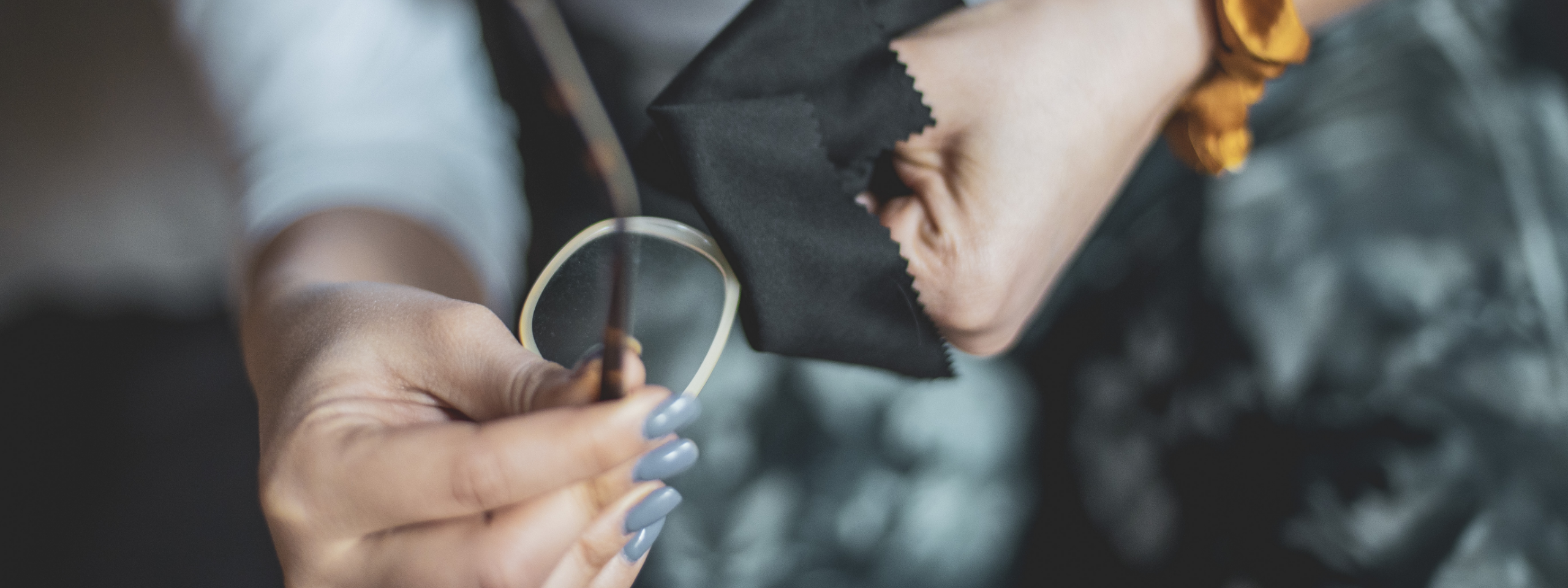 Blick auf zwei Hände, die eine Brille putzen.